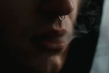 person with nose ring smoking